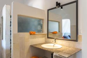 een badkamer met een wastafel en een spiegel bij Chilli Fields in Phan Rang