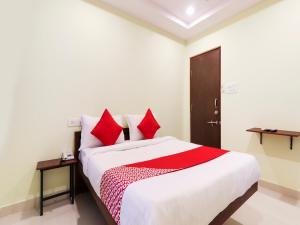 una camera da letto con un grande letto con cuscini rossi di White Ridge a Surūrnagar