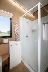 uma casa de banho com um chuveiro e um lavatório. em Gold Meadows 