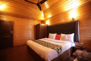 a bedroom with a large bed in a wooden room at Lake Resort The Island Hotel in Srinagar
