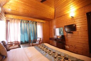 a bedroom with a bed and a tv in a room at Lake Resort The Island Hotel in Srinagar