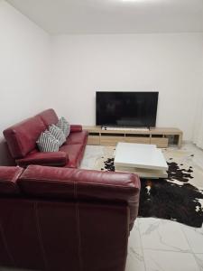 ein Wohnzimmer mit einem Sofa und einem Flachbild-TV in der Unterkunft Elsa in Pontivy