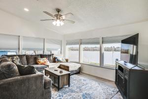 a living room with a couch and a tv at Waterfront Trinity Vacation Rental with Hot Tub! in Riverside