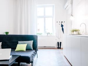 a living room with a green couch and a window at Boom Apartments in Kraków