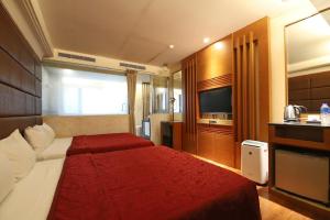 a hotel room with a bed and a television at Yosemite Hot Spring Resort in Baihe