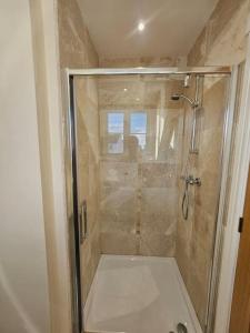 a shower with a glass door in a bathroom at Stunning 4 bed house in Rolleston