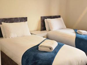dos camas sentadas una al lado de la otra en una habitación en Stunning 4 bed house, en Rolleston