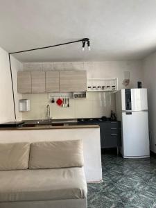 Il comprend une cuisine équipée d'un canapé et d'un réfrigérateur blanc. dans l'établissement Casa próximo ao Maracanã, à Rio de Janeiro