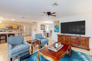 a living room with two chairs and a flat screen tv at Coastal Dreams in Venice