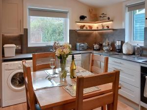 a kitchen with a table with a vase of flowers on it at Sunnybank Cottage in Inveralligin