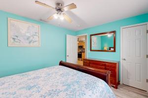 a blue bedroom with a bed and a ceiling fan at Coastal Hideaway in Venice