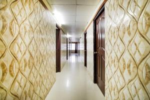 un couloir vide dans un immeuble de bureaux aux murs peints en or dans l'établissement Capital O Hotel Shanti Nivas Near Hare Krishna Hill, à Bangalore