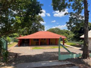 mały żółto-czerwony budynek z drzewem w obiekcie Chalé Rural - Haras Gabriela TC w mieście Nova Esperança