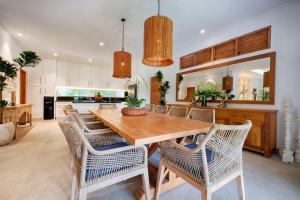 une cuisine avec une table et des chaises en bois dans l'établissement Villa Maya Scenic in Canggu, à Dalung