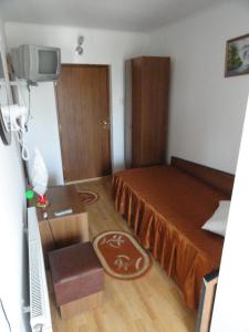 Cette petite chambre comprend un lit et une télévision. dans l'établissement Pensiune Restaurant Avangarde, à Piteşti