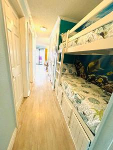 a room with two bunk beds and a hallway at Beautiful newly renovated beachfront condo at Casa Del Mars in Galveston