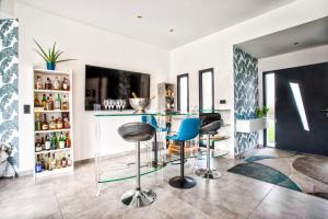 - une cuisine avec un bar et des tabourets dans la chambre dans l'établissement Villa Howard — Jacuzzi, Tranquility & Parking, à Ranville
