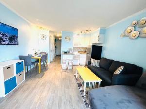 a living room with a couch and a table and a kitchen at Beautiful newly renovated beachfront condo at Casa Del Mars in Galveston