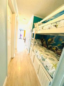 a bedroom with a bunk bed and a hallway at Beautiful newly renovated beachfront condo at Casa Del Mars in Galveston