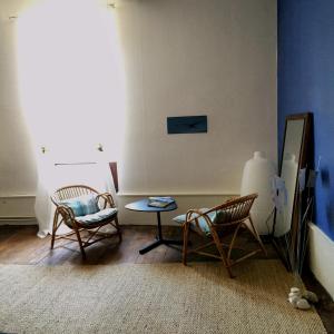 een woonkamer met 2 stoelen en een tafel bij Au détour Du Larrech in Castillon-en-Couserans