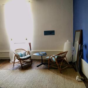 Una sala de estar con dos sillas y una mesa. en Au détour Du Larrech, en Castillon-en-Couserans