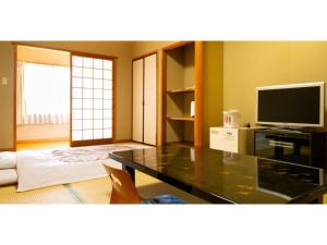 sala de estar con mesa y TV en Hotel Nissin Kaikan - Vacation STAY 02349v, en Shiso