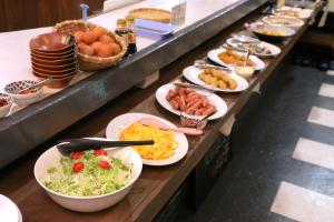 una línea de buffet con platos de comida y tazones de comida en Hotel Nissin Kaikan - Vacation STAY 02349v, en Shiso