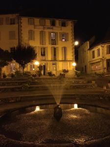 une fontaine devant un bâtiment la nuit dans l'établissement Au détour Du Larrech, à Castillon-en-Couserans