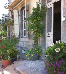 a house with potted plants in front of a door at Au détour Du Larrech in Castillon-en-Couserans