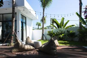a group of pillows on a patio in front of a house at Baliwood Villas - OCEAN VIEW 3BR in Canggu