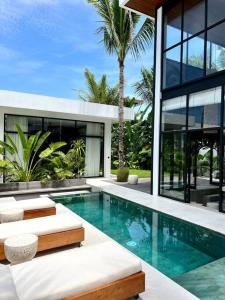 a house with a swimming pool in front of a house at Baliwood Villas - OCEAN VIEW 3BR in Canggu