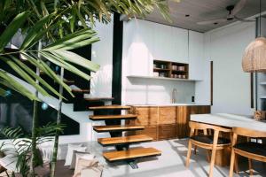 una cucina con tavolo e alcune piante e tavolo con sedie di Baliwood Villas - OCEAN VIEW 3BR a Canggu