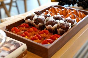 ein Tablett mit Muffins und Erdbeeren auf einem Tisch in der Unterkunft New World Guangzhou Hotel in Guangzhou