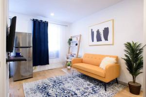 een woonkamer met een bank en een tv bij 69-3D Prime Lower East East BRAND NEW 1br Apt in New York