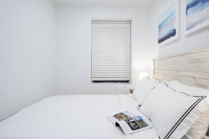 a white bedroom with a bed and a window at 69-3D Prime Lower East East BRAND NEW 1br Apt in New York
