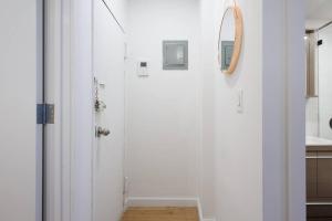 een badkamer met een witte deur en een spiegel bij 69-3D Prime Lower East East BRAND NEW 1br Apt in New York