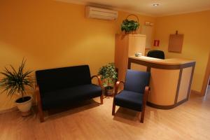 a waiting room with two chairs and a counter at Hostal Hispanico II in Salamanca