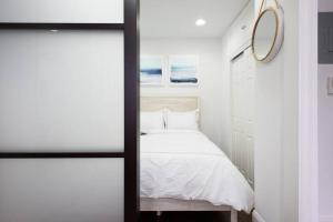 małą sypialnię z łóżkiem i lustrem w obiekcie 69-3B Prime Lower East Side BRAND NEW 1br Apt w Nowym Jorku