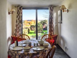 a dining room table with a view of a window at Cherry Cottage in Ipswich