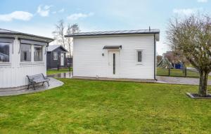 un petit bâtiment blanc avec un banc dans une cour dans l'établissement Nice Home In Slvesborg With Kitchen, à Sölvesborg