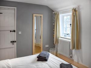 1 dormitorio con cama, espejo y ventana en Uk46354 - Old Chimneys Cottage en Wivelsfield Green