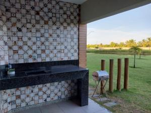una parete piastrellata con stufa e sgabello di Condomínio e resort Villa das Águas - Praia do Saco / SE a Estância Altre 4 foto