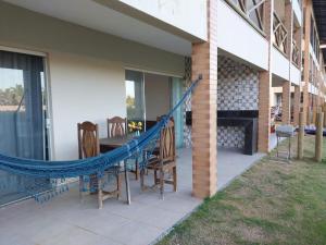 un patio con un'amaca, un tavolo e delle sedie di Condomínio e resort Villa das Águas - Praia do Saco / SE a Estância