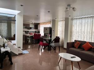 a living room with a couch and a table at HOUSE NAYARAK UBICADO A 15 min EN AUTO DE PARACAS SINO TIENES AUTO PUEDES TOMAR COLECTIVO A 5Soles in Pisco