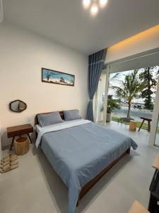 une chambre avec un grand lit et une grande fenêtre dans l'établissement Coco Villa-đảo Phú Quý, à Cu Lao Thu