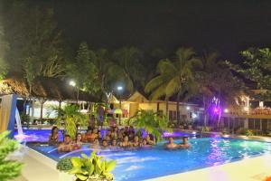 un gruppo di persone in una piscina di notte di Dumalaay Coastline Resort a Larena