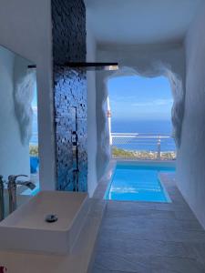 a bathroom with a tub and a swimming pool at Ninamu Pearl Guest House in Punaauia