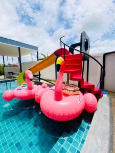Patteera Pool Villa Sattahip في ساتاهيب: مسبح مع شريحة قابلة للنفخ والمسبح قابل للنفخ