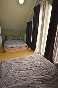 a bedroom with two beds and a large window at BORJOMI CHALET WEEKEND in Tsemi