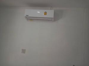 a white heater on a wall in a room at Firdous Guesthouse in Ban Khlong Hia